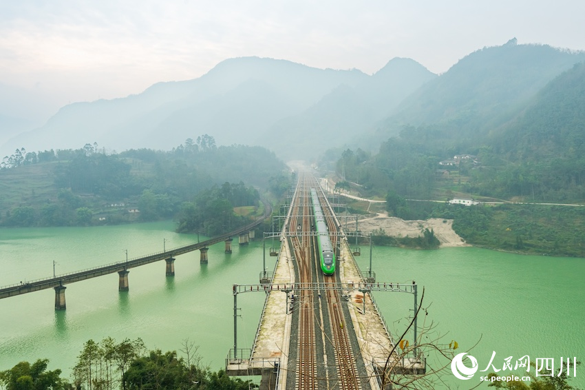 12月23日，老成昆鐵路泉水河大橋和新成昆鐵路范店子特大橋分別迎來綠皮車和“綠巨人”復(fù)興號。羅成攝