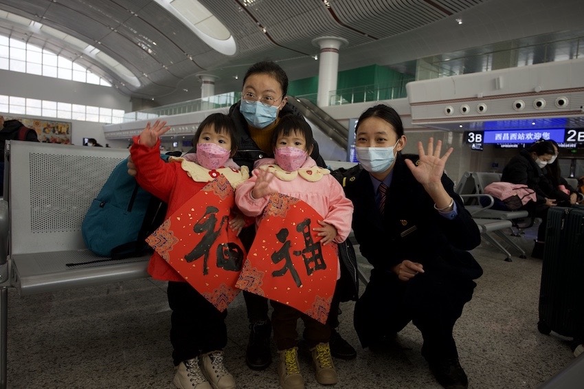 在沿途站點(diǎn)，車(chē)站工作人員為旅客送上“?！弊旨靶麓憾Y物。成都鐵路供圖