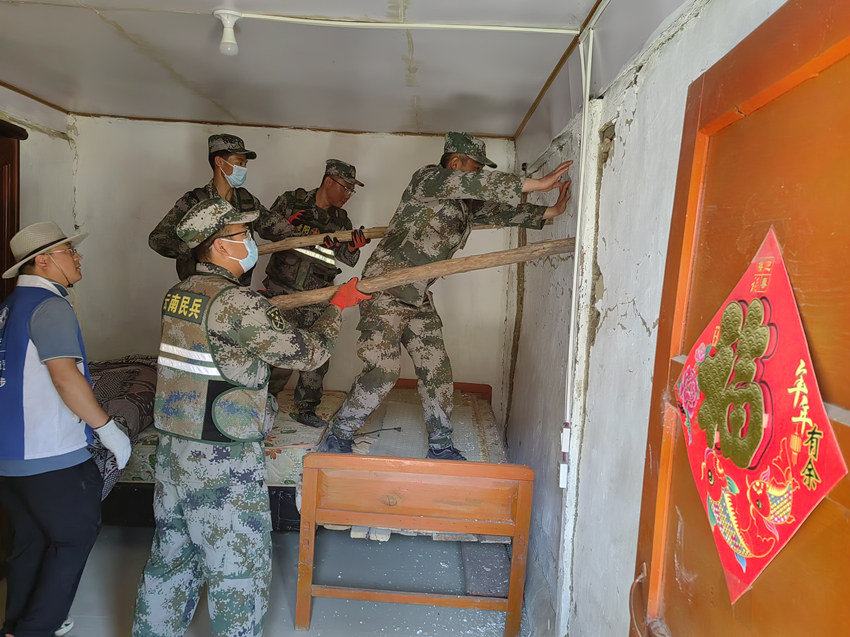 楊愛理（右一）在排除房屋安全隱患。陸軍第77集團軍某旅供圖