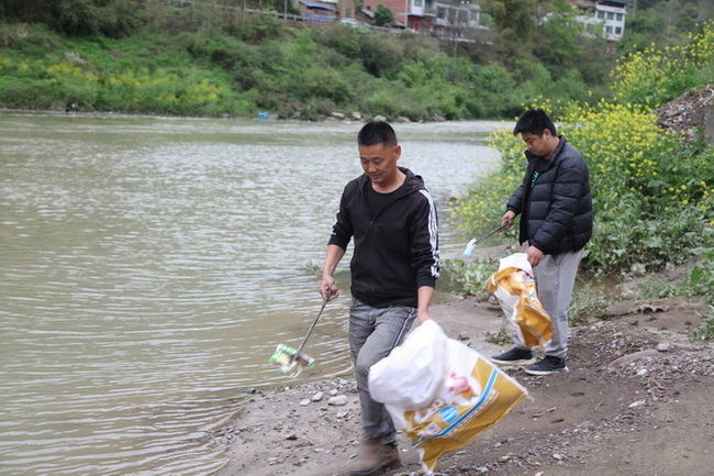 董正建父子在河道邊清理垃圾。馬發(fā)海攝